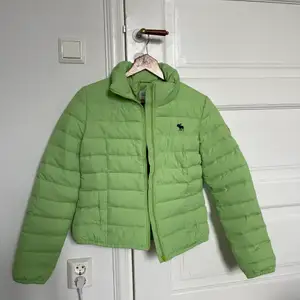 Jag säljer en oanvänd grön Ambercrombie & Fitch jacka då denna aldrig har kommit till användning. Det står att det är storlek L men den motsvarar XS.