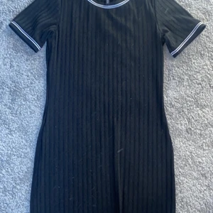 Klänning från HM - superfin ribbad klänning från hm med lite vita detaljer runt armarna och halsen, använd någon enstaka gång, stl.44 känns som en stl.40
