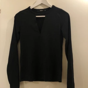 Svart topp med detalj fram - Säljer denna snygga topp från bikbok💕 Den har en liten öppning fram och är supersnygg, använder inte därför säljer jag☺️ 