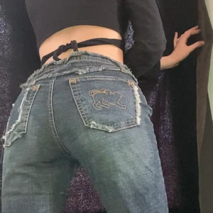 Lågmidjade jeans - Galet snygga lågmidjade  jeans med coola detaljer! Köpta på beyond retro och knappt använda av mig. Stängs med snörning så passar nog S-M beroende på hur man vill att de ska sitta. Jag på bilden är 170 cm lång. 