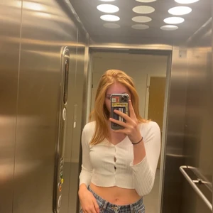 Vit tröja - En ribbad vit tröja med knappar. Säljer då den ärlige kort i armarna gör mig som är 175cm. Använd fåtal gånger. Är från Weekday å original pris låg på 350kr. Säljaren står vid extra kostnader av frakt elelr kan mötas upp i Stockholm