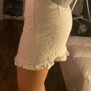 KJOL - STORLEK S men passar även M typ linne material super fin beige färg med volanger ner till och dragkedja på sidan