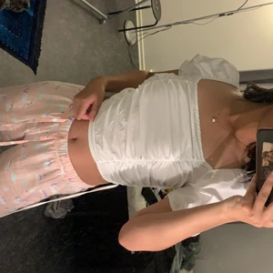 Vit t-shirt. - Den är lite genomskinlig, men annars är de en perfekt sommar tröja. Den har snörning på ryggen som går sicksack.