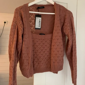 Stickad kofta med matchande topp - Oanvänd croppad kofta med tillhörande croppad topp. I stl L men är liten i storleken. Köpt på nakd från märket trendyol. 