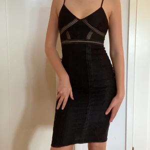 Elegant svart klänning med spetsdetaljer - Klänning med fina detaljer. Justerbara axelband. Bra skick. Storlek 32 men skulle säga 34-36. Köparen står för frakt.