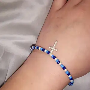 Ett armband gjort av elastisk tråd i vit och två olika nyanser av blå