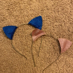 Två rosa & blå rosett öron!!  - Dom rosa är använd mycket och ena är lite böjt! Dom blå är inte så direkt mycket använda. Ser ut som nya om man frågar mig! Om ni vill köpa! Men bara ett par så går det självklart bra! Om ni vill ha båda så får ni samma pris som på en! 