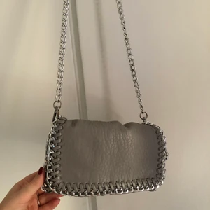 Tiamo väska - Jättesnygg grå väska från tiamo🌟 Man kan både ha den med lång kedja eller vika in den och ha två korta (som på bild nummer 2&3) Inga defekter!! 