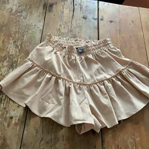 En beige shorts-kjol (shorts inuti men ser ut som en fin kjol). Från SHEIN, och aldrig använt. Storlek Small.