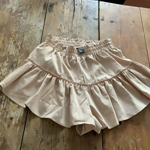 Beige SHEIN byx-kjol - En beige shorts-kjol (shorts inuti men ser ut som en fin kjol). Från SHEIN, och aldrig använt. Storlek Small.