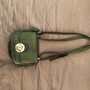 Väska grön  - Kross-body väska i grönfärg  säljs för 125kr. Har använt flight som bis er men skinnet håller i sig och kvaliten är superbra. Köpte väskan för ca 5 år sen på någon secondhand butik. 