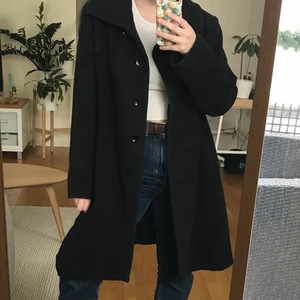 Ullkappa - Mörkgrå kappa i 70% ull, 10% kashmir och 20% polyamide från Flare Collection.