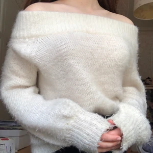 Vit stickad tröja - Säljer denna fina offshoulder-tröjan från Gina! Den är i fluffigt och skönt material och är använd max 5 ggr. Tyvärr har den en liten fläck framtill (se sista bilden) som är svår att få bort, men tröjan går att ha bak och fram ifall man vill (jag har det på 1a/2a bilden)!💗