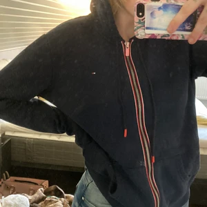 Higfiger Hoodie Gammal modell - Jättemysig hoodie är nästan helt ny, andvänd kanske 2 gånger max. finns tyvärr ett litet hål vid  högra sömmen men det syns knabbt. Annars är tröjan i nyskick👍🏻👍🏻  köparen betalar frakt.