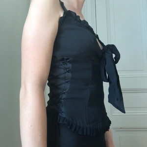 Korsett med snörning - Korsettopp med snörning i sidorna! Dragkedja baktill. Justerbara axelband samt omfång, storlek saknas men skulle säga att den passar personer mellan XS och M då den har snörning.