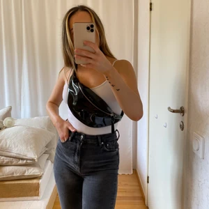 Glansig bumbag - Snygg glansig svart bumbag. Reglerbart band. GRATIS FRAKT.