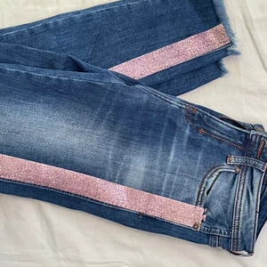 Jeans med glitter kant  - Jeans med rosa/glittrig stripe på sidorna, säljes pga att de är för små.. 