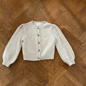 Stickad kofta - Beige stickad kofta från zara i storlek 152. Knappar med diamanter, stora armar. Använd några gånger men i väldigt fint skick!!