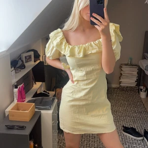 Söt klänning med volang  - Söt gul klänning med volang. Helt ny och oanvänd med prislappen kvar. Påse med önskade axelband medföljer