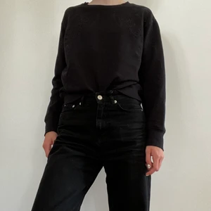 Svart sweatshirt från H&M - En svart sweatshirt från H&M. På axlarna och en bit ner på ärmarna är ett hålmönster med blommor/blad, som ni kan se på bild 3. Sparsamt använd. Tveka inte att kontakta mig vid frågor!