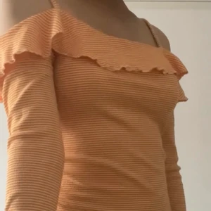 Långärmad Gina off-shoulder topp volang - Randig orange vit Långärmad off-shoulder topp med volang från Gina i stl M. Rätt hängig av i sig vid framförallt byst området på mig, annars sitter den elegant på i övrigt. Passar nog från XS-L beroende på hur löst/tight man vill ha den. Kom gärna på med egna bud, pris kan annars alltid diskuteras vid snabb affär🥰 Frakt ingår ej i givna priset, tillkommer dock på kundens egna bekostad isf 