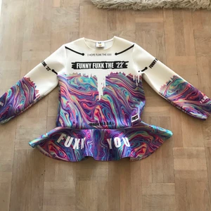 Mönstrad tröja med volang - Material i neoprene. Kortare ärmar. Sparsamt använd och är i fint skick. Står ingen storlek i men passar mig som är en S/M.