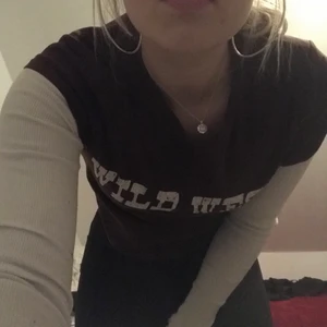 Wild West croppad Tee - Wild West croppad Tee, den är bekväm och den passar med en vit tröja under!! Den är super lätt att style.  Den passar bra i vinter och på sommaren.  Har bara använt hemma.
