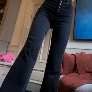 bootcut jeans - Svarta högmidjade bootcut jeans med knäppning. Basic men elegant med knapparna, vida / utsvängda. I modell ”next level stretch” från American Eagle outfitters (UK 8). Hämtas i Gamla stan eller skickas mot fraktkostnad. 🖤