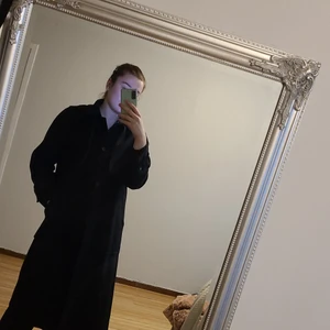 Mörkblå Mango kappa i storlek M - Säljer nu min fina vinterkappa från Mango son är köpt 2 år sen. Den är i bra skick och är ganska lång som man ser i bilden (jag är 180). Material: Återvunnen ull