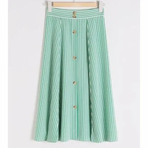 Kjol från & Other stories - Jättefin och söt grön/ vit randig, halvlång kjol med knappar från & Other stories. Kjolen är i storlek 34. Väldigt bra skick. 💚🤍