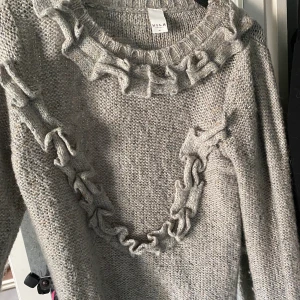 Stickad tröja - Grå stickad tröja med volanger. Supersöt och i gott skick. Storlek M men passar även S. Märke: Vila