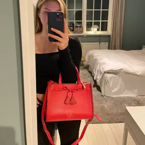 Röd väska från Kate Spade. Med väskan kommer även den tillhörande tygpåsen. 
