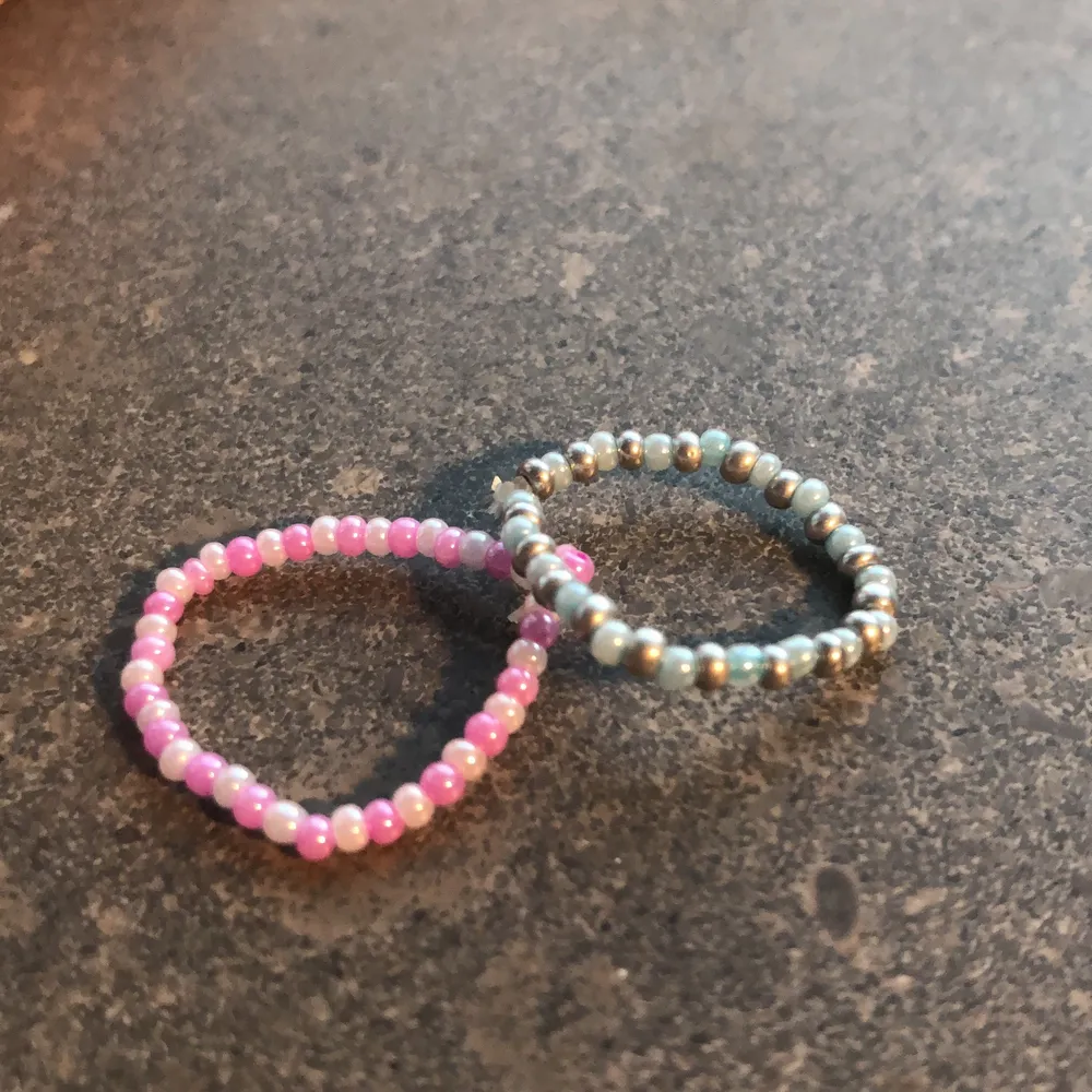 Två jättefina handgjorda ringar av små pärlor och elastisk tråd 🥰 En rosa/vit  och en ljusblå/silvrig. Om ni vill ha andra färger eller veta de exakta måtten kan ni höra av er 💕 19 kr styck eller 29 kr för båda🤩. Accessoarer.