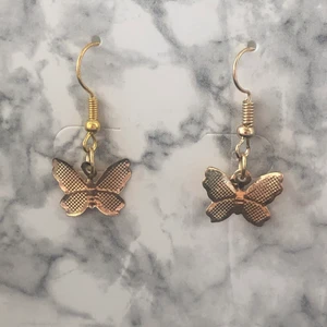 Örhängen  - Guldiga fjärils örhängen. Oanvänd.