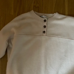 Beige stickad tröja från Zara - Nyligen inköpt stickad tröja från Zara, säljes pga att den inte kommer till användning. Lite oversize i modellen och har knappar som går att knäppa upp vid urringningen. Något bredare armar vilket ger en så fin detalj✨ Mysig tröja som passar perfekt till hösten🍂🌻🍄🍁 Storlek S men passar även M. 