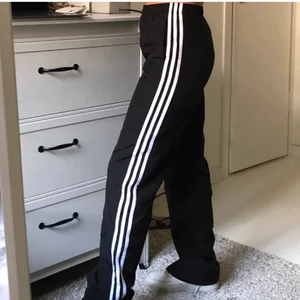 Adidas trackpants - Klassiska svarta adidasbyxor! Liten dragkedja längst ner vid foten. Innerbenslängd: 78cm. Köpta på plick i mycket fint skick, säljer vidare pga för små på mig. Bilderna har jag lånat:) du som köper står för frakten.