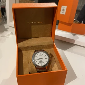 Tory Burch klocka - Superfin Tory burch klocka, köpt på NK i Göteborg 2018. Köpte för 2999:- men då det finns mycket små repor, inte alls märkbara vid användning så säljer jag den för 500kr. Pris kan diskuteras vid snabb affär. Säljer då jag inte får användning för den längre tyvärr. Klockan har en sekundvisare (Tory burch märket i mitten nedre) som roterar. Skickar mer än gärna fler bilder vid intresse. . 