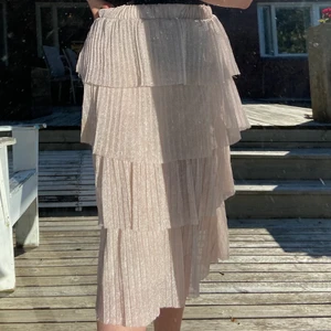 Glittrig kjol - Glittrig midikjol, färgen är lite svår att fånga på bild men den är åt det rosa hållet. Jättefin till sommarens fester! Bara använd en gång💖 köpt från NA-KD, storlek M. 100kr eller buda i kommentarerna