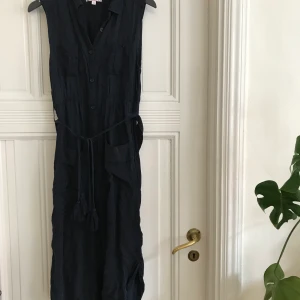 Skjortklänning  - Mörkblå skjortklänning med band i midjan och knappar hela vägen framtill. Smickrande passform och fint skick! Lite kortare i sidorna än framtill och baktill. 