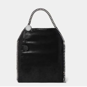 McCartney väska  - Intresse koll denna ❌FAKE❌ Stella McCartney väskan som är köpt utomlands. Jätte bra skick aldrig använd. Den är svart och det finns mycket utrymme i väskan och typ fickor inuti. Vid bra  bud så släpper jag den 💓💓öka gärna med ca 50kr 💗💗buda i kommentarerna💗💗 köparen står för frakt!