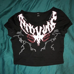 Svart croptop med coolt tryck - Bara använd några gånger, strlk M men ganska liten, dock stretchig. 