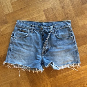 Vintage Wrangler jeansshorts strl 26/27 - Jättesnygga jeansshorts från köpta vintage från Wrangler. Säljer pga tyvärr har växt ur dom. Var verkligen en favorit! Hittar ingenstans någon storlek på dom men skulle tippa på 26/27/S.