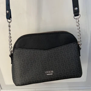 Guess väska med långt band - Guess väska i bra skick, har många fickor både initi och utanpå väskan. 