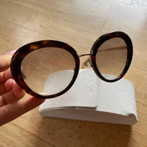 Prada solglasögon  - Äkta solglasögon från Prada använt väldigt sparsamt fåtal gånger. Nypris 2500kr - säljer för 1000kr