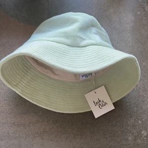 Lack of Color Bucket Hat - Supertrendig bucket hat i mintgrön frotté från det australiensiska märket Lack of Color. Hatten har UV skydd och en praktisk ficka.  Storlek L. Helt oanvänd och kostar runt 1000kr nypris. 