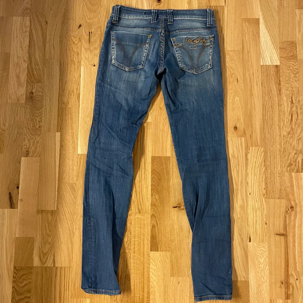 Sjuka VINTAGE MISS SIXTY jeans i lågmidjad modell. Så coola detaljer på allt från bakfickorna till knappen till dragkjedjor längst ner vid fötterna. Gott vintage skick. Midjemått 74cm innerbenslängd 78,5cm. (Har tyvärr inga bilder med jeansen på då de är för små på mig som har W30+ och är 183cm). Bild 1 är lånad, samma märke och liknande modell, bild 2-3 är mina. Skriv för fler bilder!. Jeans & Byxor.