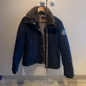 Ridjacka från JH Collection - Marinblå jacka med päls(fusk)detaljer på kragen och gulddetaljer. 