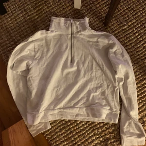 Vit zip up-tröja i strl S/M - Säljer denna knappt använda vita zip-up sweater med halvhög krage, passar strl S/liten M.