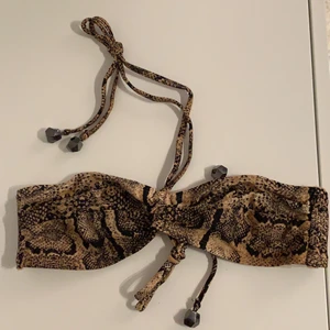 Bikinitopp med djurmönster  - Snygg bikinitopp i strl S i fint skick. Finns anti-slip, snygg stenar på snörningarna och hål att lägga inlägg om man vill. 