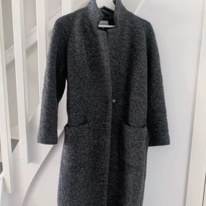 Ullkappa från Ganni - Grå ullkappa från Ganni i storlek 36/S. Väldigt varm och skön. Använd två vintrar, men fortfarande i finfint skick.   Modellen heter ”Fenn long wrap coat”. Nypris ca 3500 kr. 